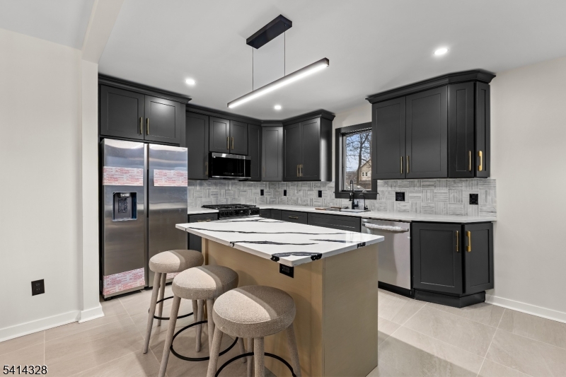79 3rd Street Somerville, NJ 08876 - Photo 2 of 20 a kitchen with stainless steel appliances a stove a sink a microwave a refrigerator and chairs