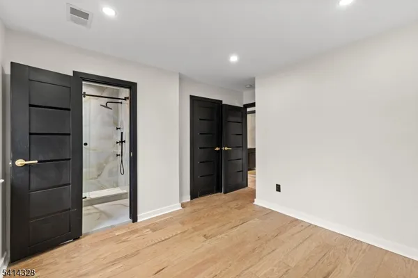 a big room with closet and wooden floor