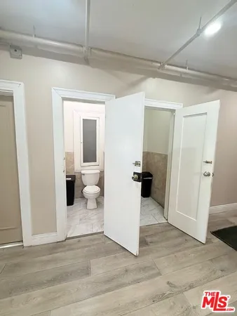 a view of a hallway with wooden floor and a living room