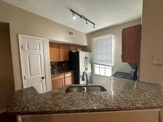 a kitchen with sink and refrigerator