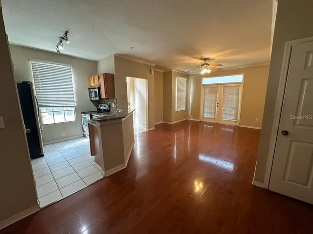 a kitchen with stainless steel appliances wooden floor and large window