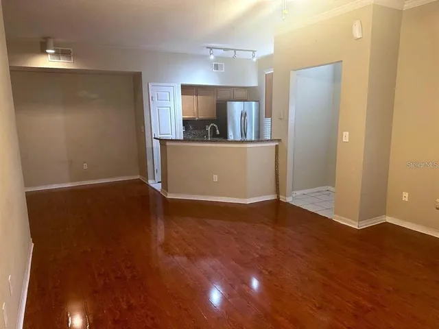 a view of a room with wooden floor and a window