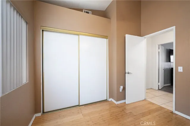 a view of an empty room with closet and a window