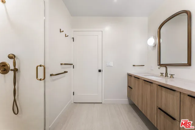a bathroom with a double vanity sink a mirror and a shower