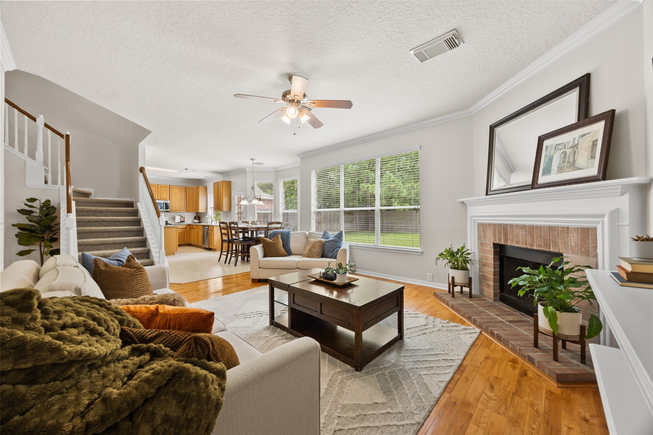 2219 Louetta Brook Lane Spring, TX 77388 - Photo 19 of 34 Spacious family room seamlessly connected to the kitchen and dining area, highlighted by a fireplace and expansive backyard views.