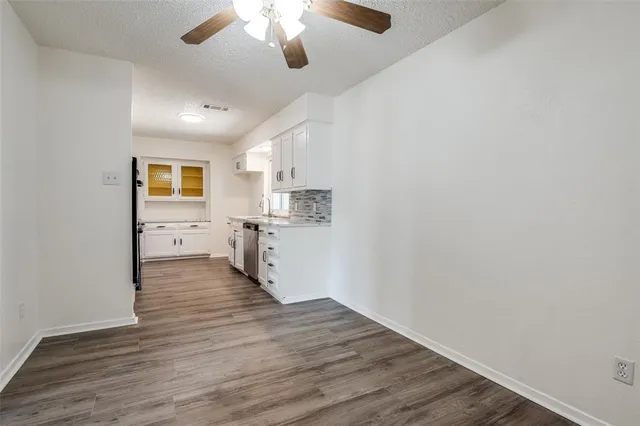 a view of a kitchen with a microwave and wooden floor