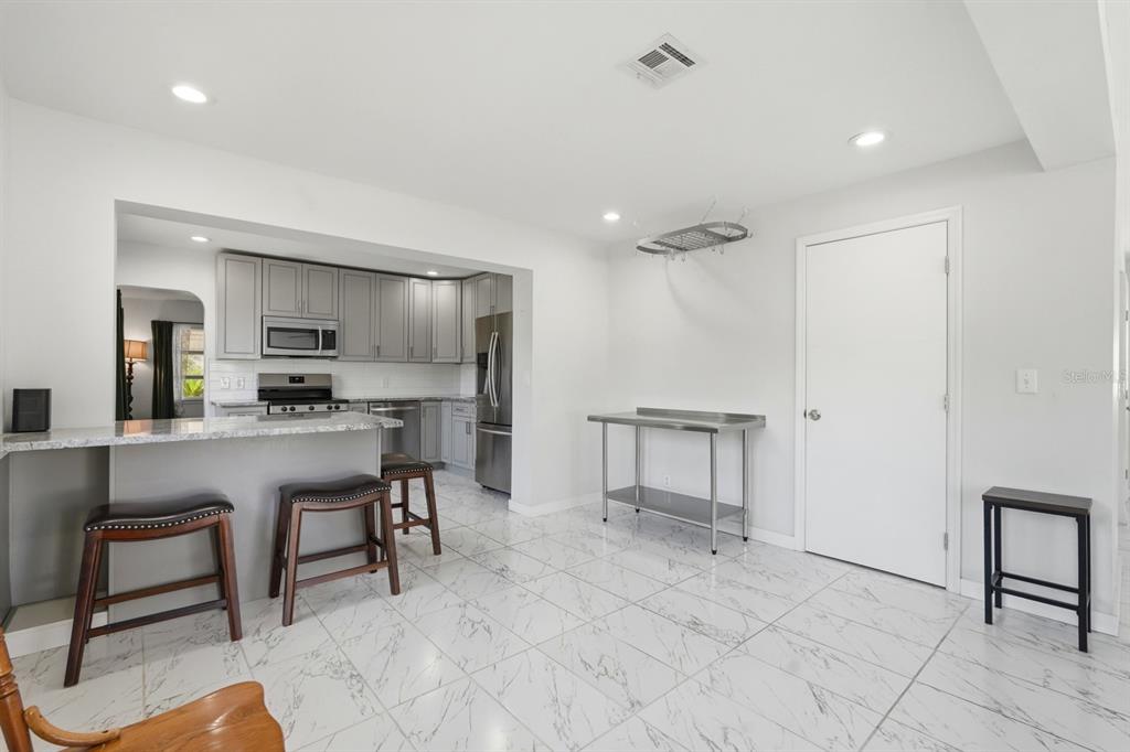 231 North Ridgewood Avenue Ormond Beach, FL 32174 - Photo 8 of 52 a kitchen with a refrigerator and table chair