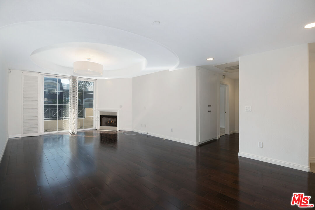 4400 Cartwright Avenue, Unit 201 Toluca Lake, CA 91602 - Photo 14 of 30 an empty room with wooden floor and windows