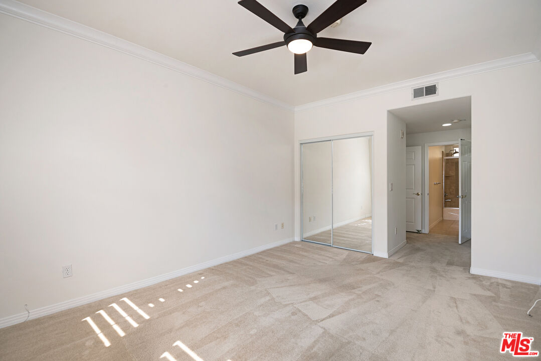 4400 Cartwright Avenue, Unit 201 Toluca Lake, CA 91602 - Photo 22 of 30 an empty room with closet and a chandelier fan