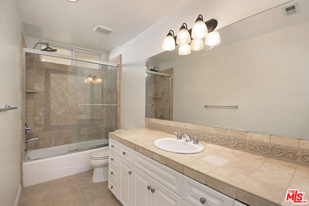 4400 Cartwright Avenue, Unit 201 Toluca Lake, CA 91602 - Photo 24 of 30 a bathroom with a granite countertop sink a toilet and shower