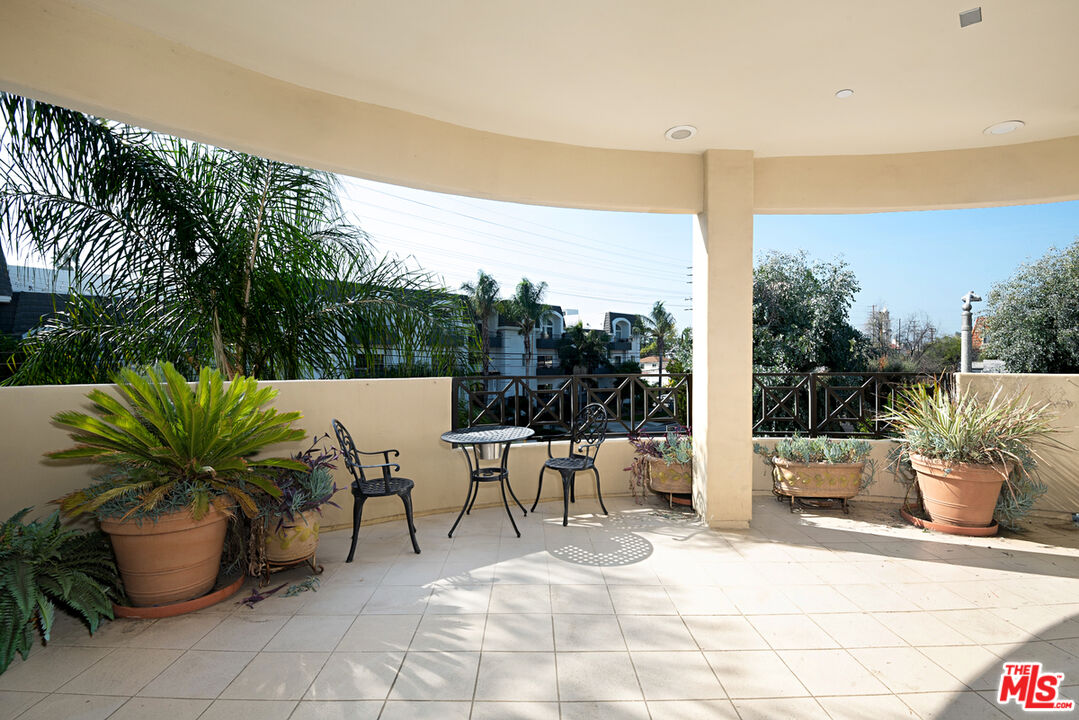 4400 Cartwright Avenue, Unit 201 Toluca Lake, CA 91602 - Photo 28 of 30 a view of a patio with a dining table and chairs with a potted plants