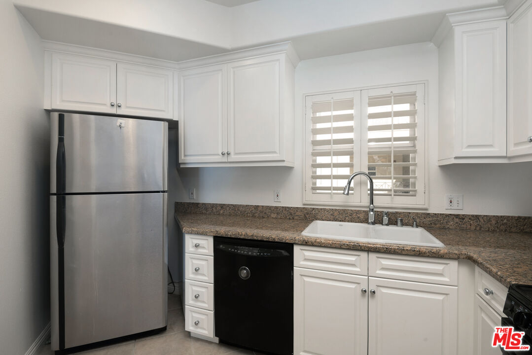 4400 Cartwright Avenue, Unit 201 Toluca Lake, CA 91602 - Photo 7 of 30 a kitchen with a refrigerator and cabinets