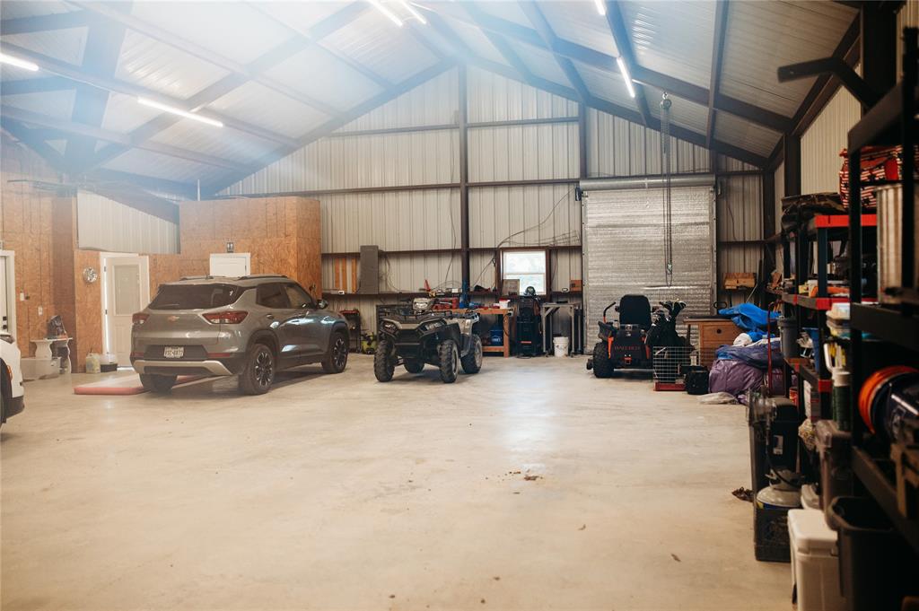 208 Chicken Field Road Whitewright, TX 75491 - Photo 32 of 40 Spacious metal building featuring a concrete floor, exposed structural beams, and multiple overhead light fixtures