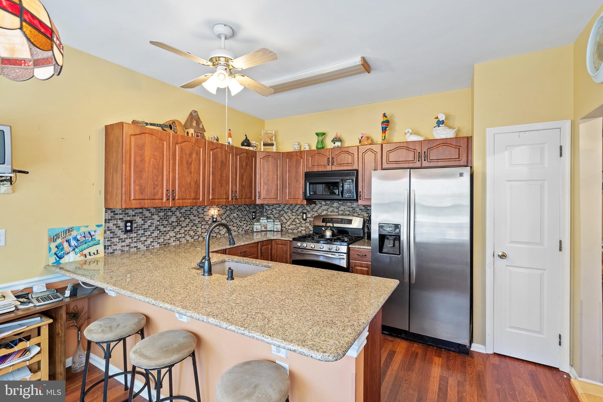 10 Hampton Road Manahawkin, NJ 08050 - Photo 12 of 36 a kitchen with granite countertop a table chairs stove and refrigerator