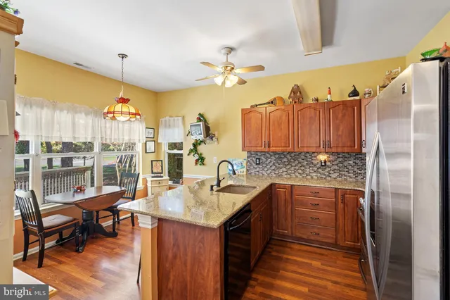a kitchen with a sink dishwasher and a refrigerator with wooden floor
