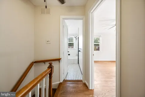 a view of a hallway with wooden floor and staircase