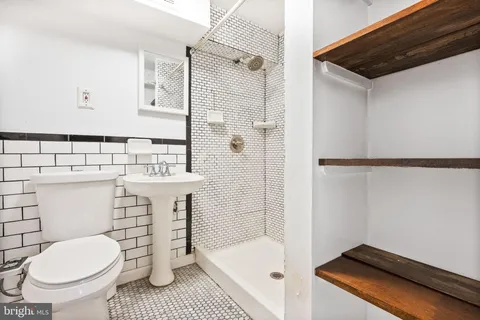 a bathroom with a sink a toilet and shower