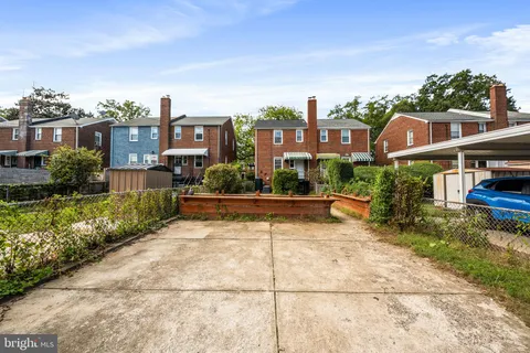 a front view of a house with a yard and potted plants