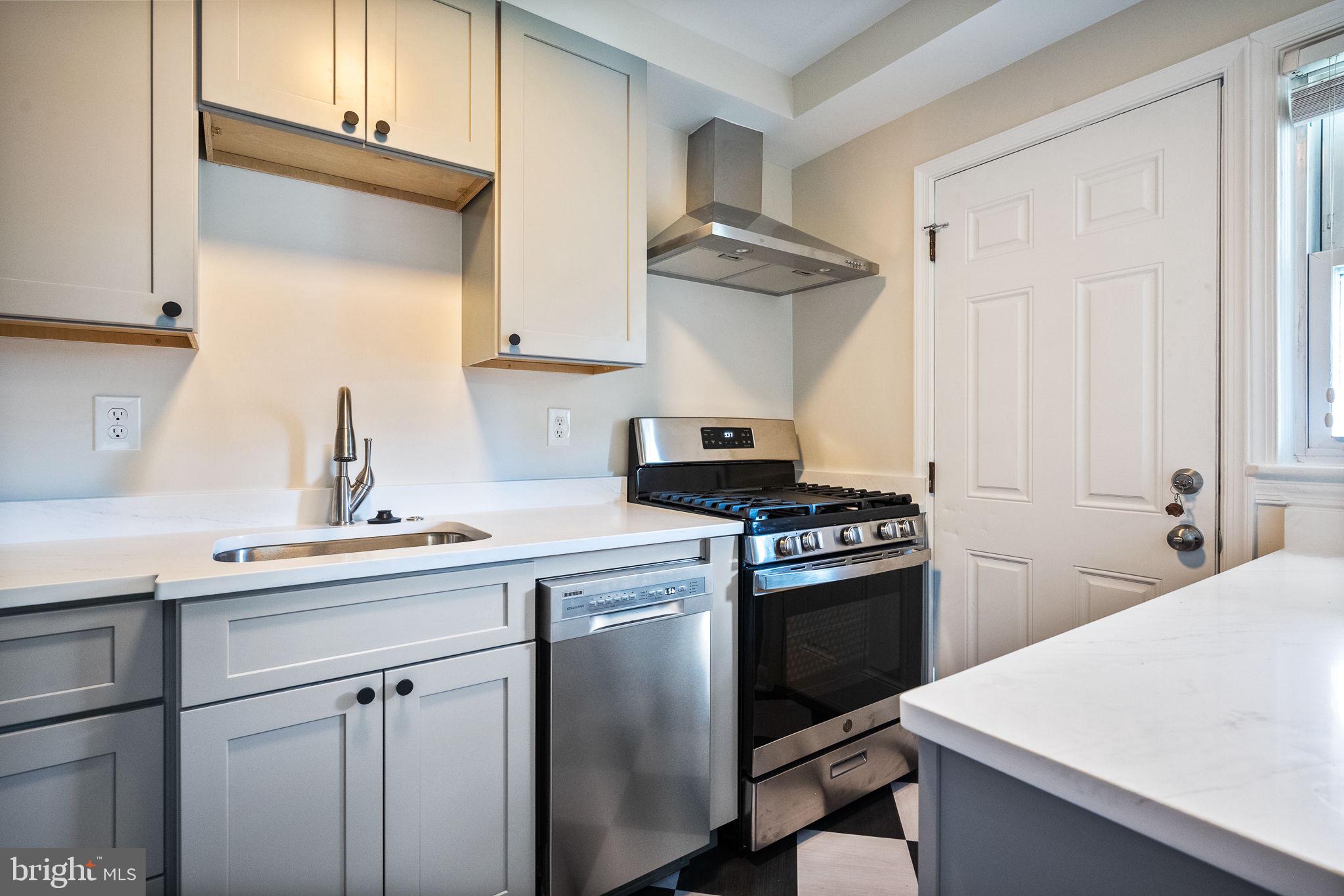 4937 11th Street Northeast Washington, DC 20017 - Photo 9 of 28 a kitchen with a sink dishwasher stove and white cabinets