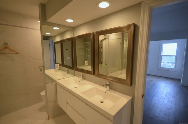 a bathroom with a double vanity sink a mirror and a shower