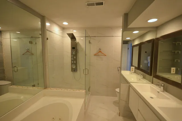a bathroom with a double vanity sink toilet and shower