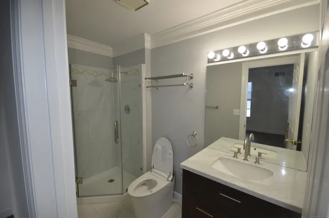 a bathroom with a sink a toilet and shower