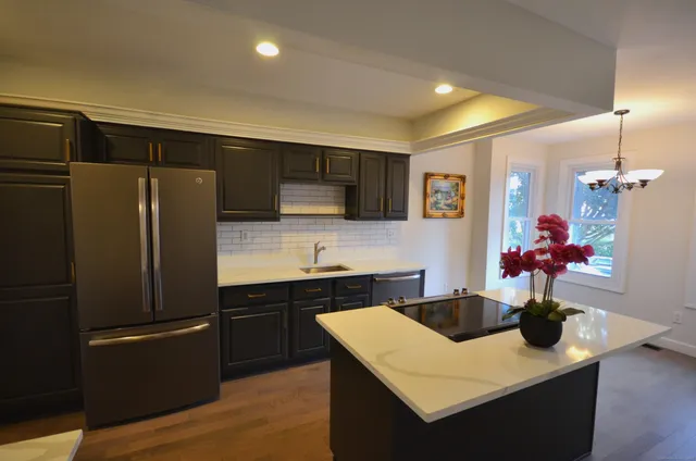 a kitchen with stainless steel appliances granite countertop a sink refrigerator and microwave