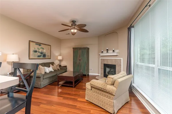 a living room with furniture wooden floor and a large window