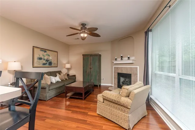 a living room with furniture wooden floor and a large window