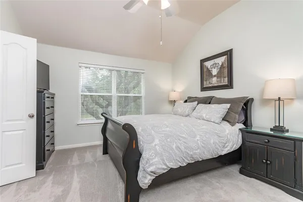 a bed room with a bed and a mirror on dresser