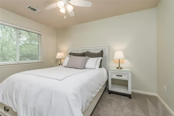 a bedroom with a bed and a lamp next to a window