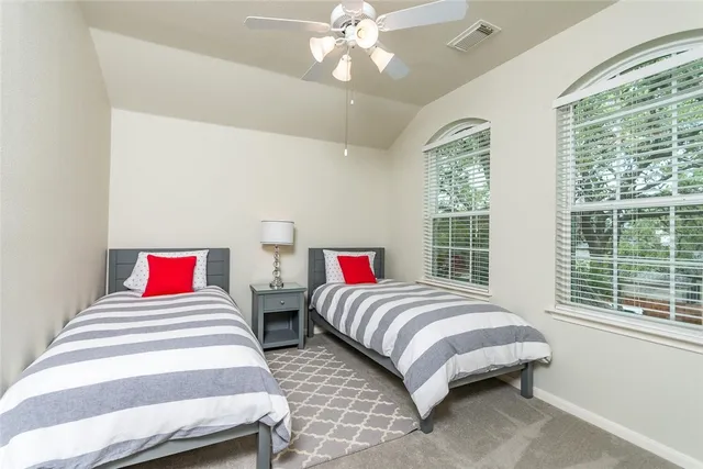 a bedroom with two bed and a lamp