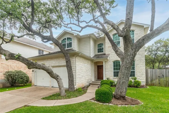 a front view of a house with a yard and garage