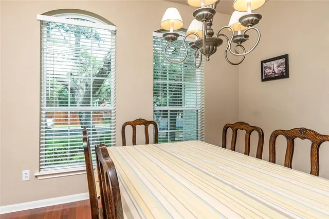 a view of a dining room with furniture a chandelier and wooden floor