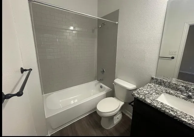 a bathroom with a granite countertop sink toilet and shower