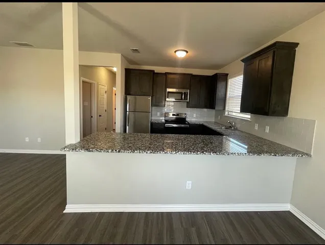 a view of a kitchen with a sink and a large window