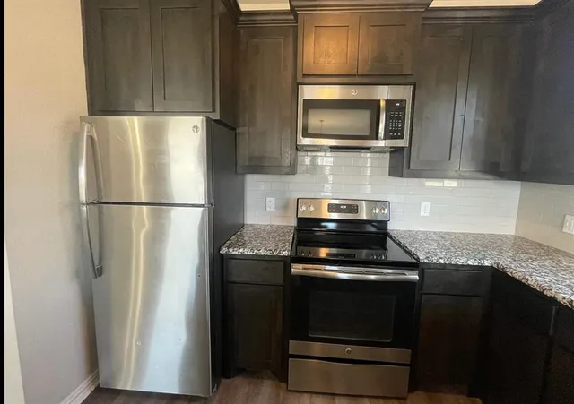 a kitchen with a refrigerator stove and microwave
