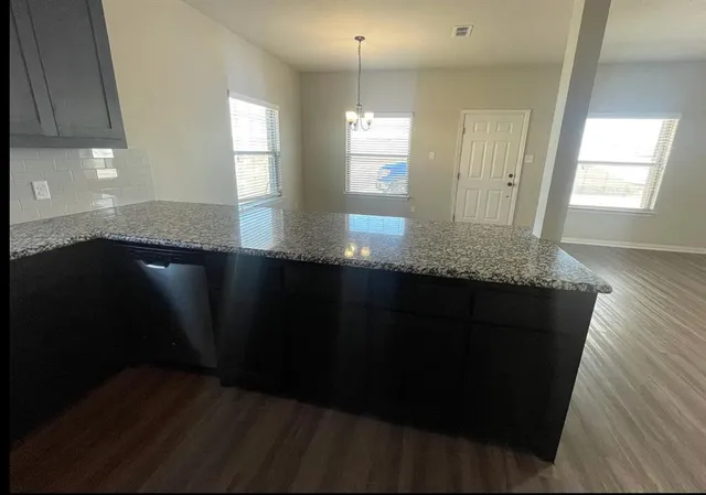 a kitchen with granite countertop sink and cabinets