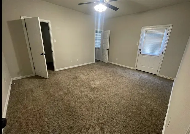 an empty room with closet and mirror