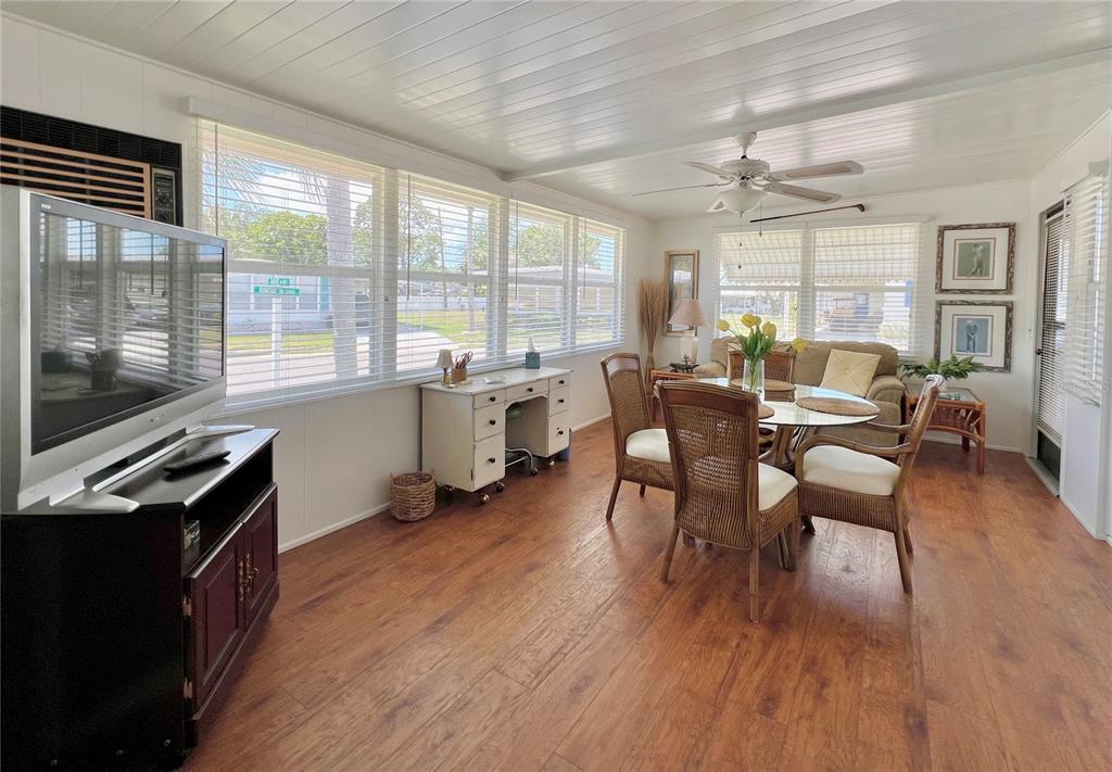 1100 South Belcher Road, Unit 245 Largo, FL 33771 - Photo 16 of 69 a dining room with wooden floor a chandelier a flat screen tv and windows