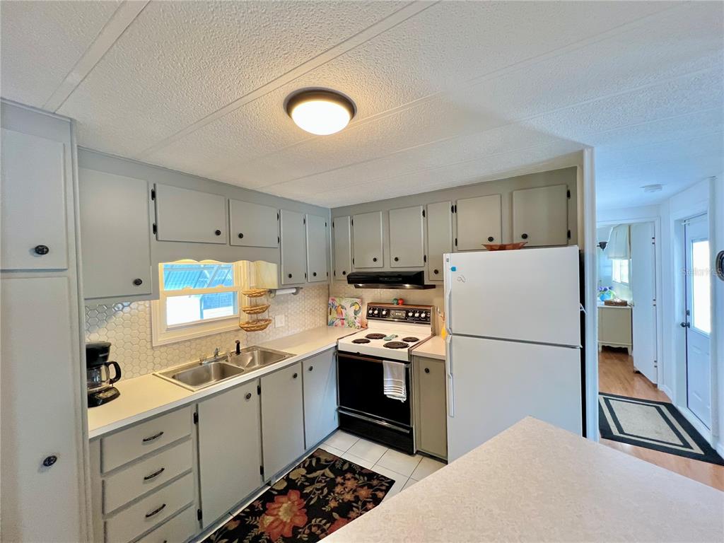 1100 South Belcher Road, Unit 245 Largo, FL 33771 - Photo 23 of 69 a kitchen with a refrigerator a stove top oven and white cabinets