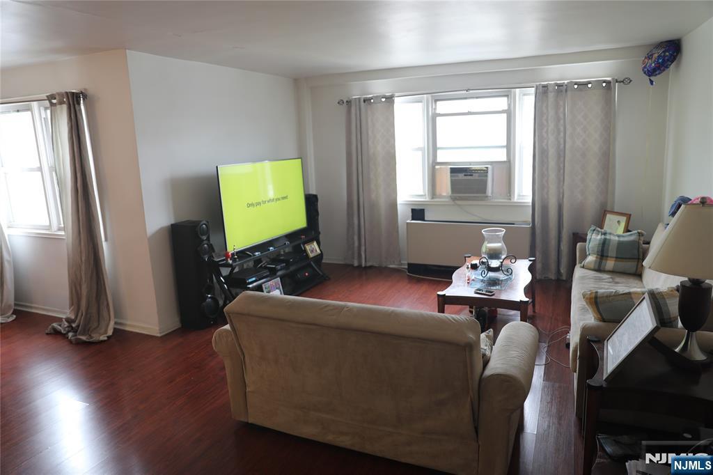 39 East 39th Street, Unit 1E Paterson, NJ 07514 - Photo 4 of 18 a living room with furniture and a flat screen tv