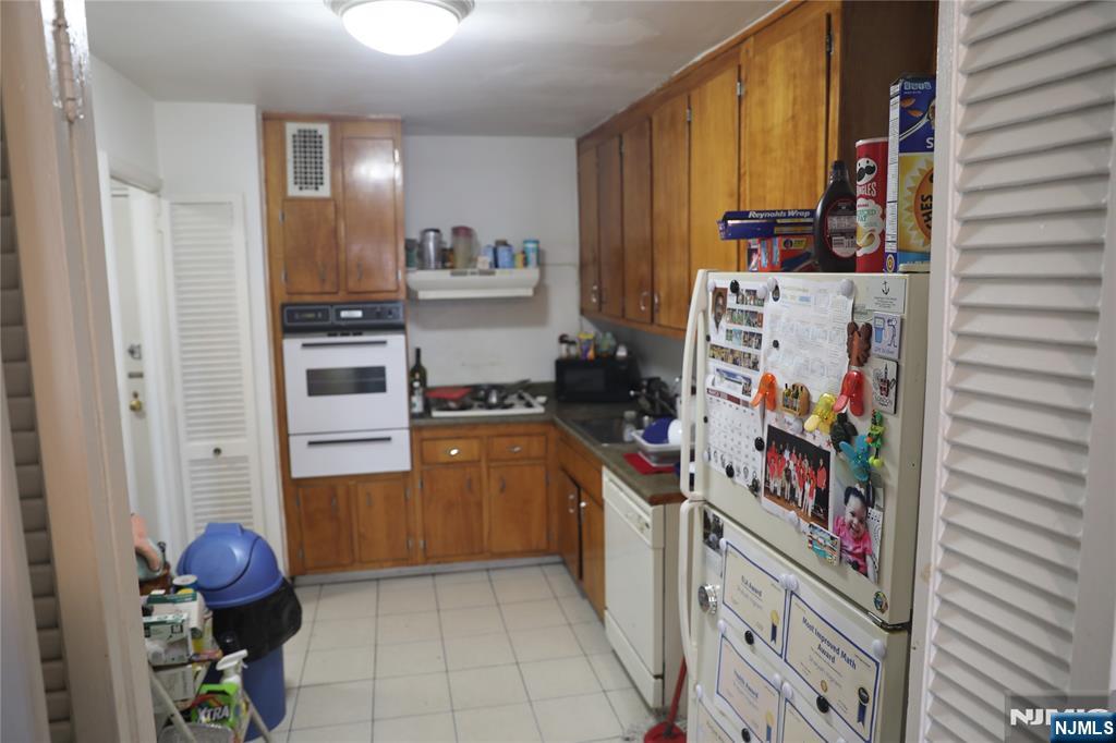 39 East 39th Street, Unit 1E Paterson, NJ 07514 - Photo 7 of 18 a kitchen with stainless steel appliances a refrigerator and a stove