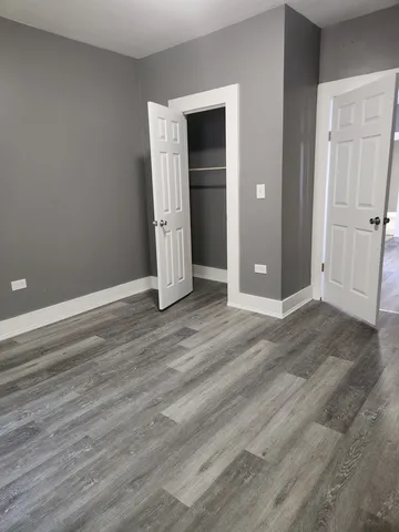 an empty room with wooden floor and closet