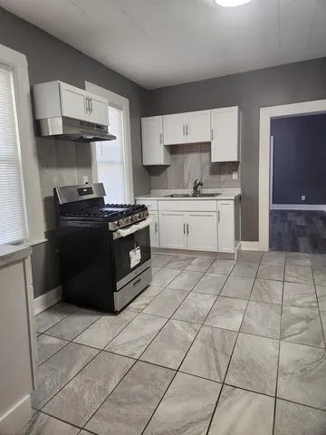 a kitchen with a stove top oven and cabinets