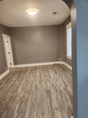 a view of a room with wooden floor and a hallway