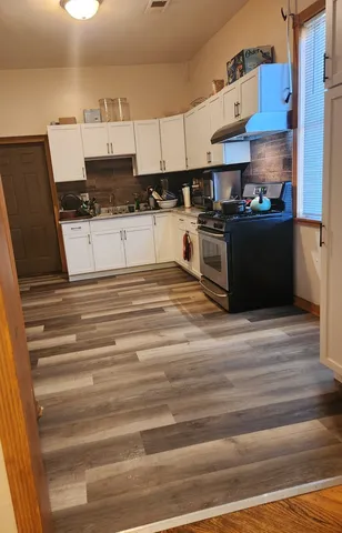 a kitchen with stainless steel appliances granite countertop a sink stove and cabinets