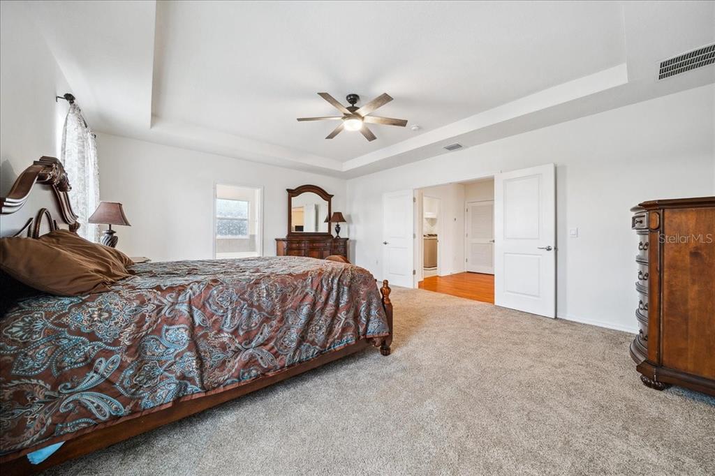8110 Southwest 59th Terrace Ocala, FL 34476 - Photo 22 of 35 a bed room with a bed and a chandelier