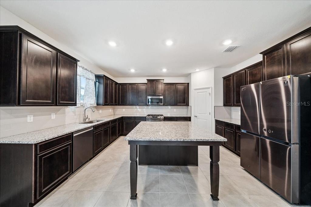 8110 Southwest 59th Terrace Ocala, FL 34476 - Photo 9 of 35 a kitchen with stainless steel appliances granite countertop a sink stove refrigerator and cabinets