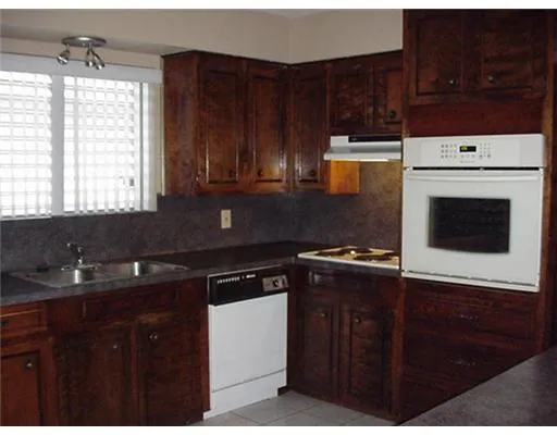 a kitchen with a sink a stove and cabinets